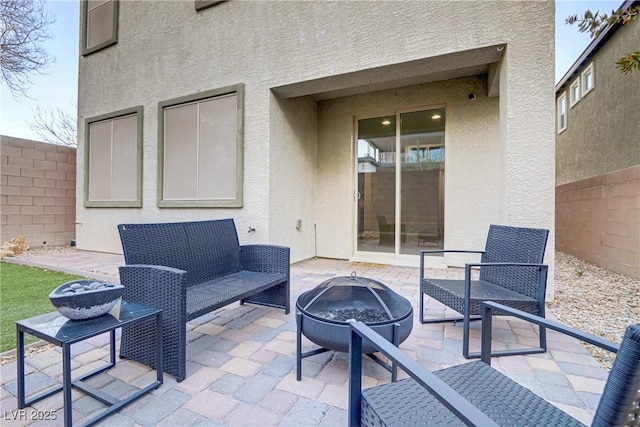 view of patio featuring a fire pit and fence