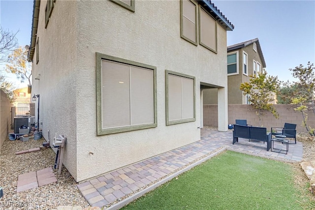 rear view of house with a patio, central air condition unit, fence, and stucco siding