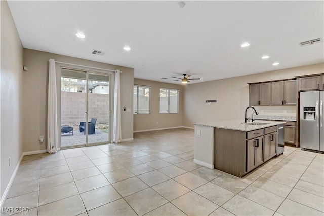 kitchen with fridge with ice dispenser, light tile patterned flooring, a sink, and visible vents