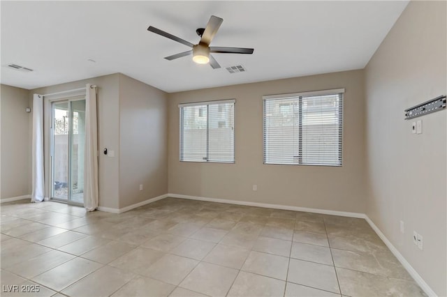 empty room featuring a ceiling fan, visible vents, baseboards, and light tile patterned flooring