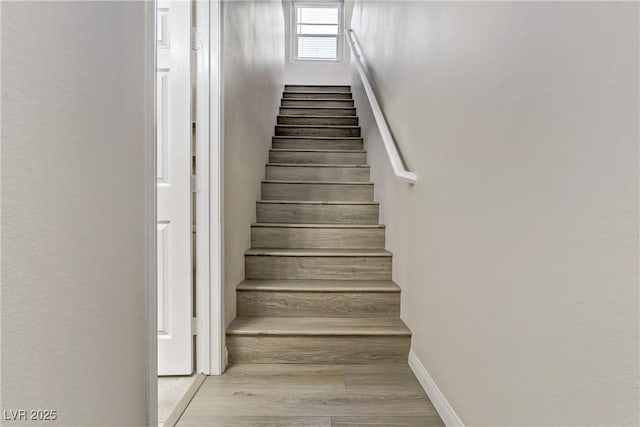 stairway featuring baseboards and wood finished floors