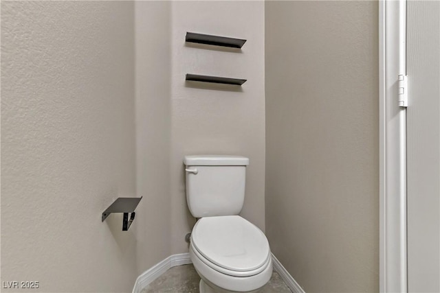 bathroom featuring toilet and baseboards