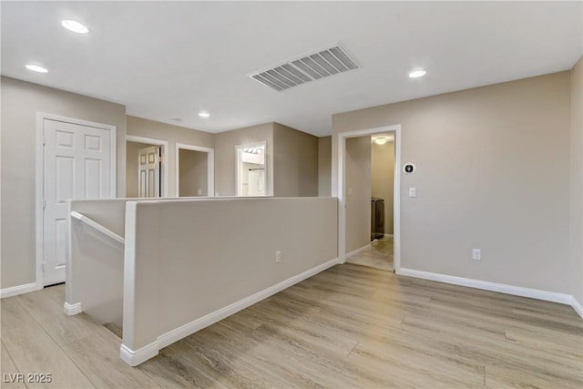 spare room featuring light wood-style floors, recessed lighting, visible vents, and baseboards