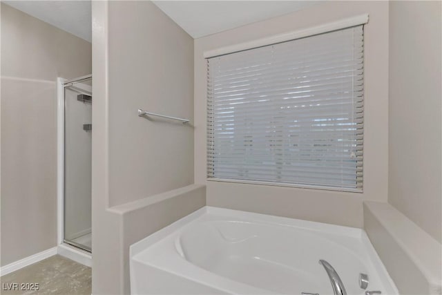 bathroom featuring a stall shower and a garden tub