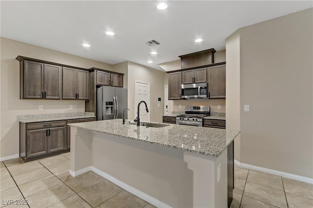 kitchen featuring stainless steel appliances, visible vents, a sink, and dark brown cabinetry