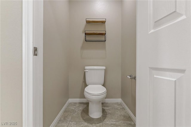 bathroom featuring baseboards and toilet