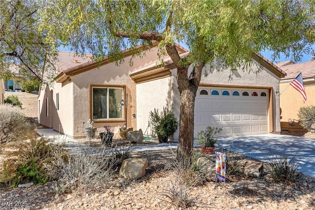 mediterranean / spanish house with driveway, a tiled roof, an attached garage, and stucco siding