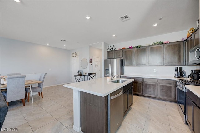 kitchen with light tile patterned floors, stainless steel appliances, a sink, and visible vents