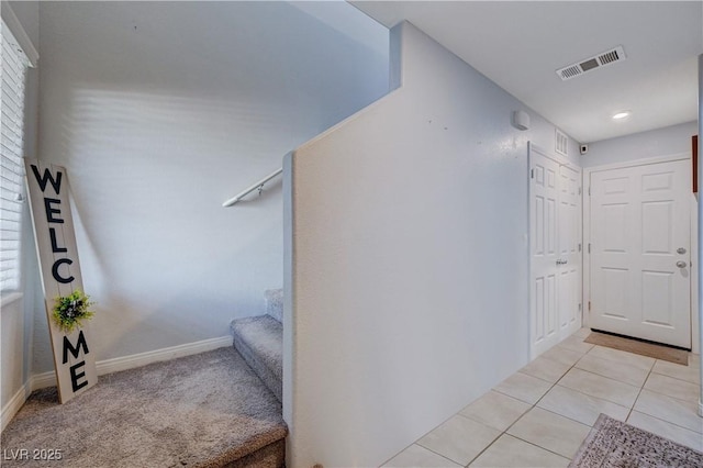 interior space with stairs, light tile patterned floors, visible vents, and baseboards