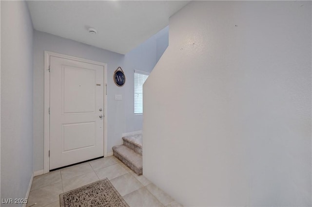 doorway with stairway, baseboards, and light tile patterned floors