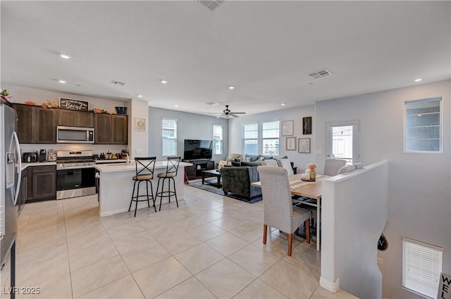 dining space featuring recessed lighting, a healthy amount of sunlight, visible vents, and light tile patterned floors