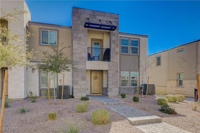 view of front facade featuring stone siding and central air condition unit