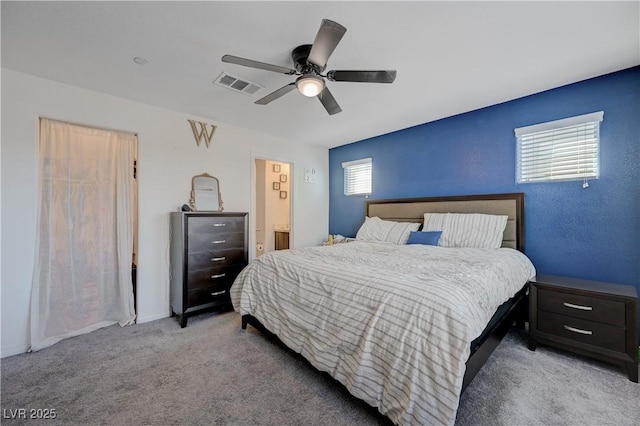 bedroom featuring ensuite bathroom, carpet, visible vents, and a ceiling fan