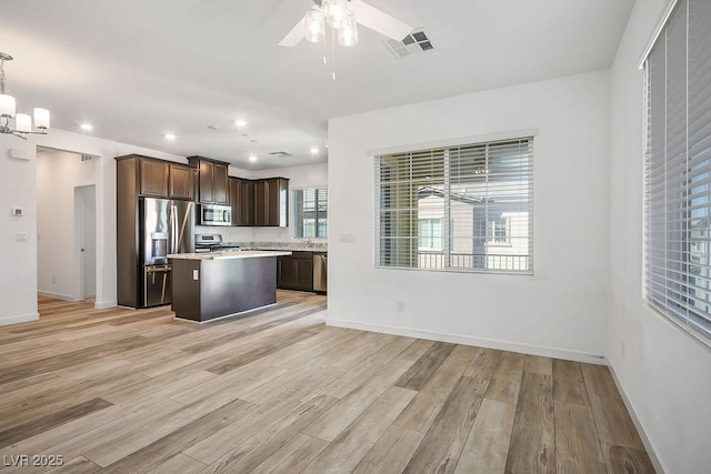 kitchen featuring stainless steel appliances, light countertops, visible vents, light wood-style flooring, and a kitchen island