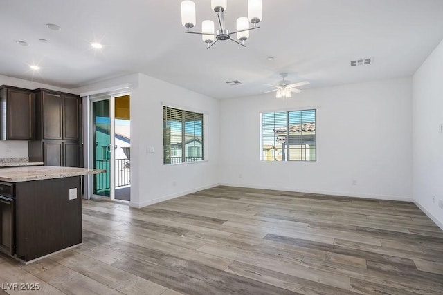 unfurnished dining area with recessed lighting, ceiling fan with notable chandelier, visible vents, baseboards, and light wood-type flooring