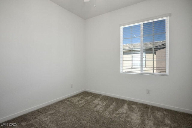 carpeted empty room featuring ceiling fan and baseboards