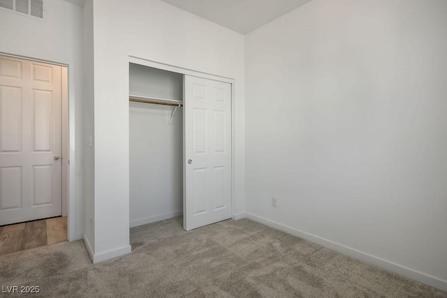 unfurnished bedroom with carpet, visible vents, and baseboards