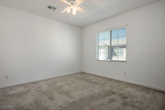 carpeted empty room with ceiling fan, visible vents, and baseboards