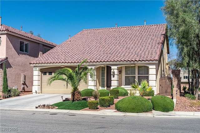 mediterranean / spanish-style house with stucco siding, a gate, a garage, driveway, and a tiled roof