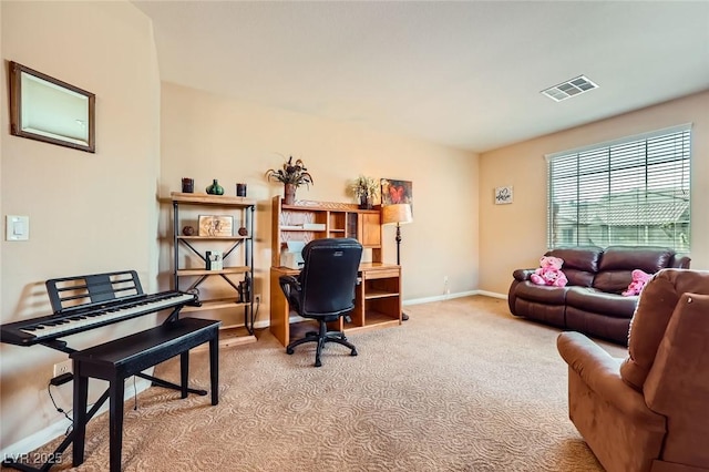office space with baseboards, visible vents, and light carpet