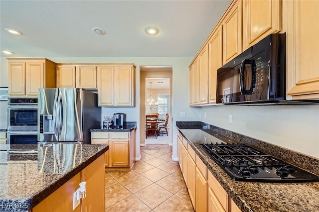 kitchen with dark stone countertops, black appliances, light tile patterned floors, and recessed lighting