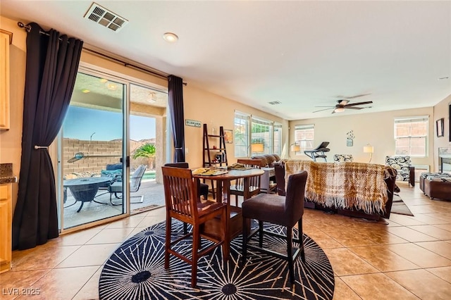 dining area featuring light tile patterned floors, visible vents, and ceiling fan