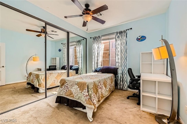 carpeted bedroom with visible vents, baseboards, a closet, and a ceiling fan