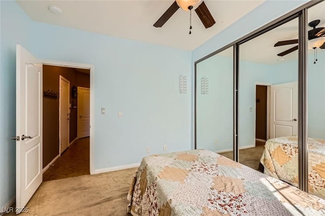 bedroom with light carpet, baseboards, a closet, and ceiling fan
