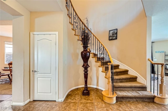 stairway with tile patterned floors and baseboards