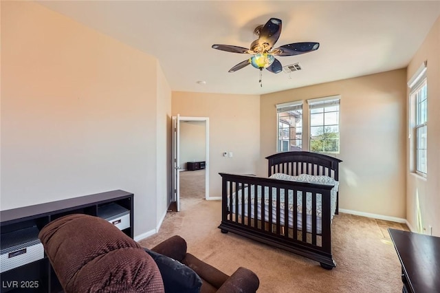 bedroom featuring visible vents, light colored carpet, a ceiling fan, and baseboards