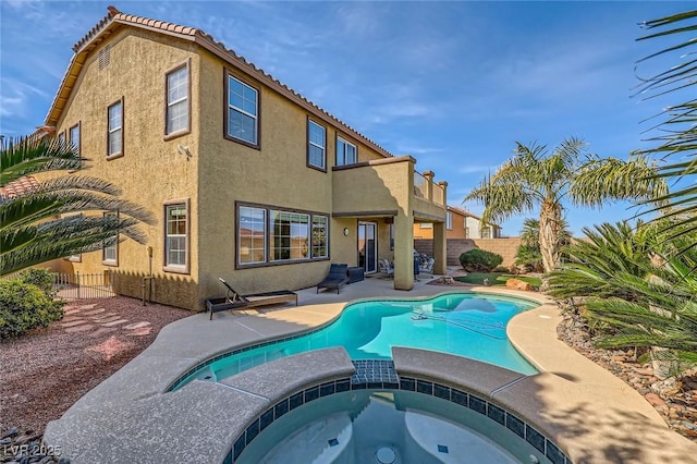 view of pool featuring a patio area, a pool with connected hot tub, and a fenced backyard