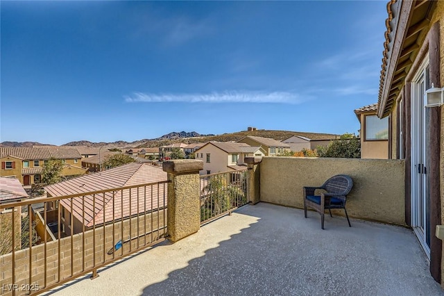 view of patio featuring a residential view, a mountain view, and a balcony