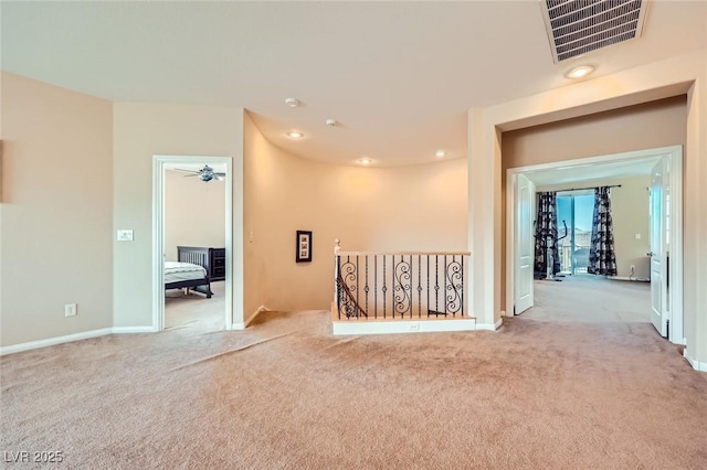 carpeted empty room featuring baseboards and visible vents