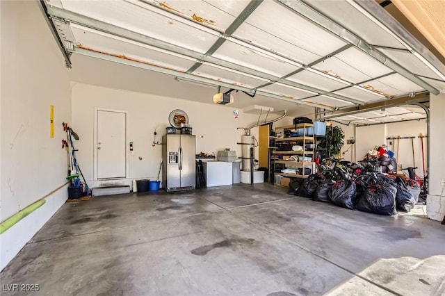 garage with stainless steel fridge and a garage door opener