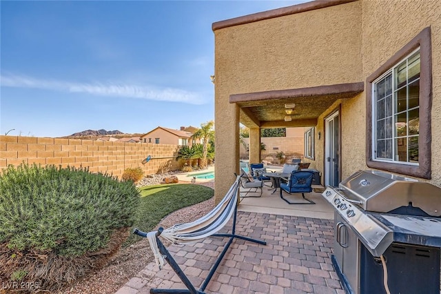 view of patio featuring area for grilling, outdoor dining space, a fenced backyard, grilling area, and a fenced in pool