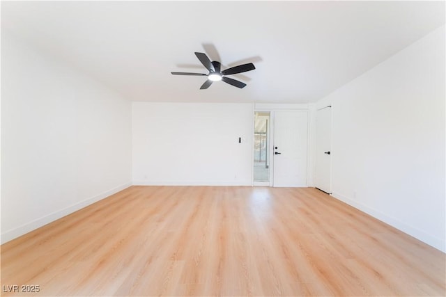 spare room with ceiling fan, light wood finished floors, and baseboards