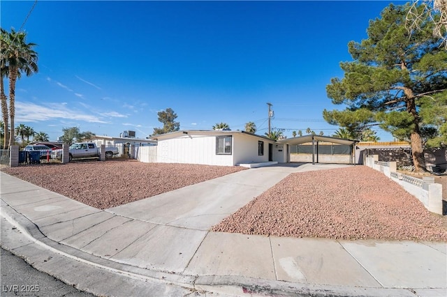 view of front of home featuring an attached carport, driveway, and fence