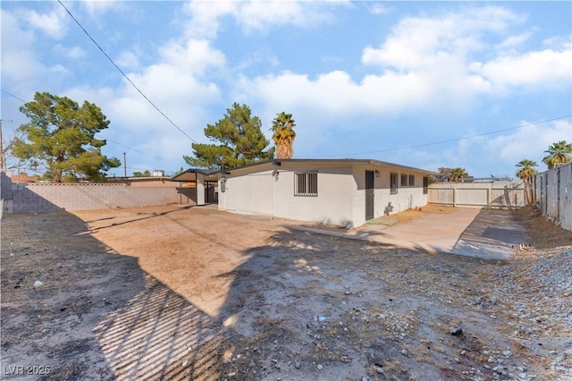 back of property featuring a fenced backyard and stucco siding