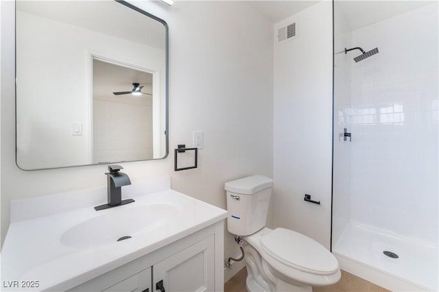 full bath with toilet, visible vents, tiled shower, and vanity