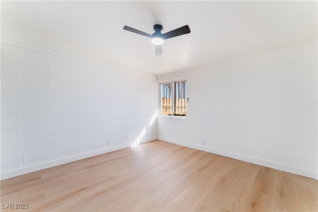 unfurnished room with light wood finished floors, a ceiling fan, and baseboards