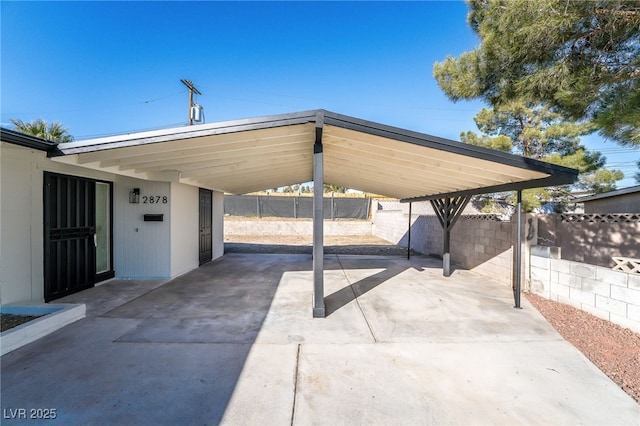 view of patio / terrace with an attached carport and fence