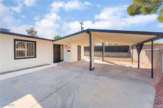 view of patio with a carport and fence