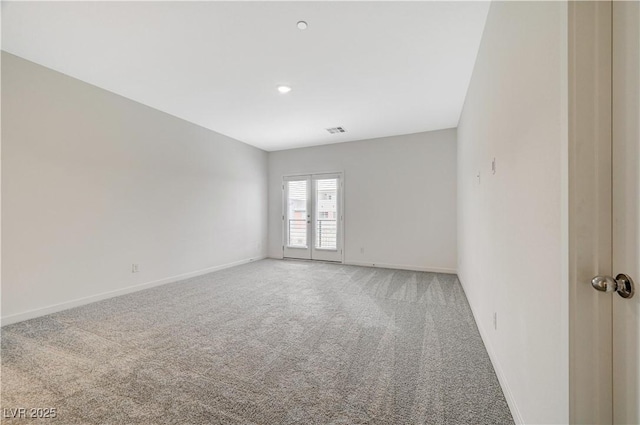 empty room featuring french doors, carpet, visible vents, and baseboards