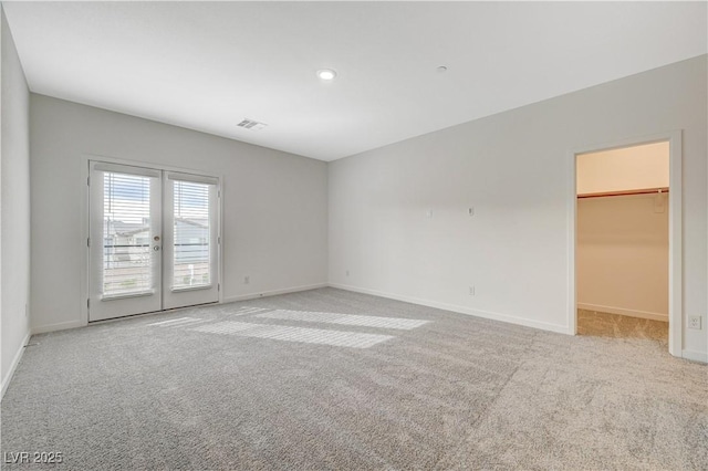 carpeted empty room featuring french doors, recessed lighting, visible vents, and baseboards