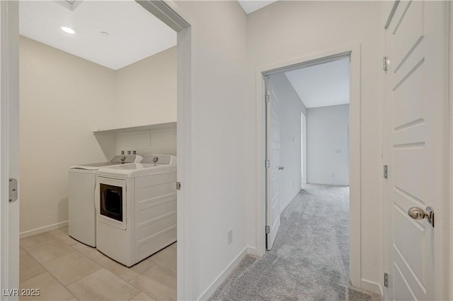 washroom featuring light tile patterned floors, light colored carpet, laundry area, baseboards, and washer and clothes dryer