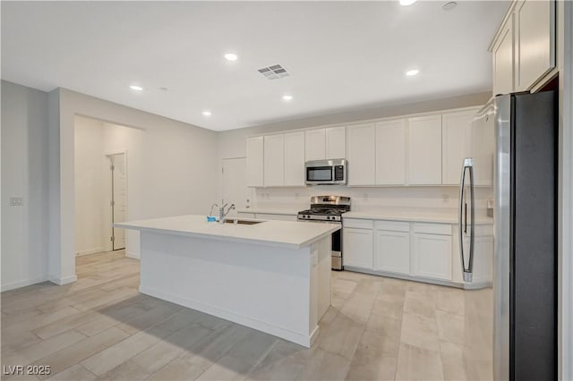 kitchen with stainless steel appliances, a sink, visible vents, white cabinetry, and light countertops