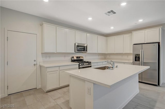 kitchen with appliances with stainless steel finishes, visible vents, a sink, and white cabinetry