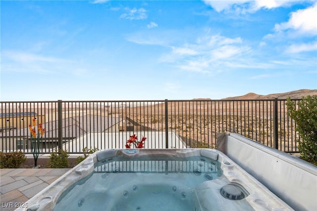 exterior space featuring fence, a hot tub, and a mountain view