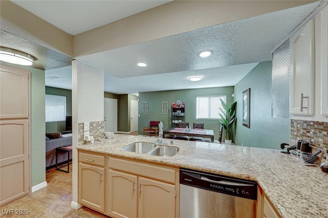 kitchen featuring decorative backsplash, a peninsula, stainless steel dishwasher, a sink, and recessed lighting