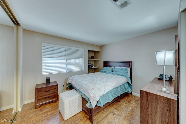 bedroom featuring light wood-type flooring, visible vents, and baseboards